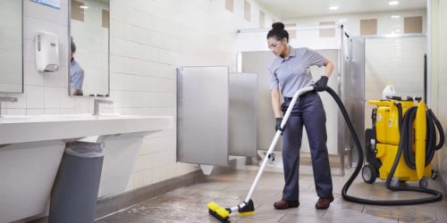 A Commercial Janitorial crew member cleaning a commercial restroom inside a commercial office building / facility in Mountain View, California 