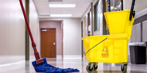 A commercial wet mop and a commercial mop bucket to clean a commercial hard surface floor  