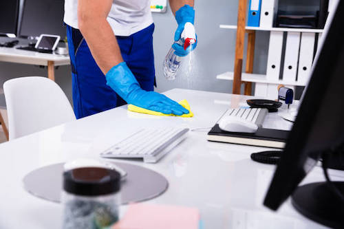 commercial Janitorial crew member cleaning, wiping and disinfecting a business office area near San Jose, California